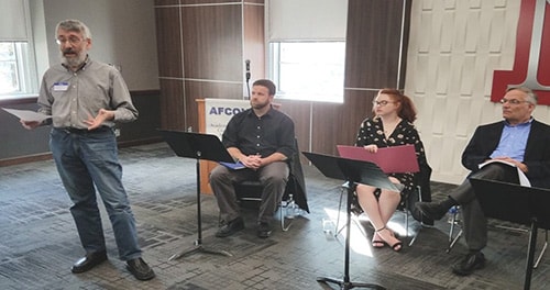 David Moshman introduces the Angels Theatre Company reading of the play Sedition at the 2017 annual meeting of the Academic Freedom Coalition of Nebraska. Seated behind David (from left to right) are cast members Bret Olsen, Jules Howard, and Dick Nielsen.