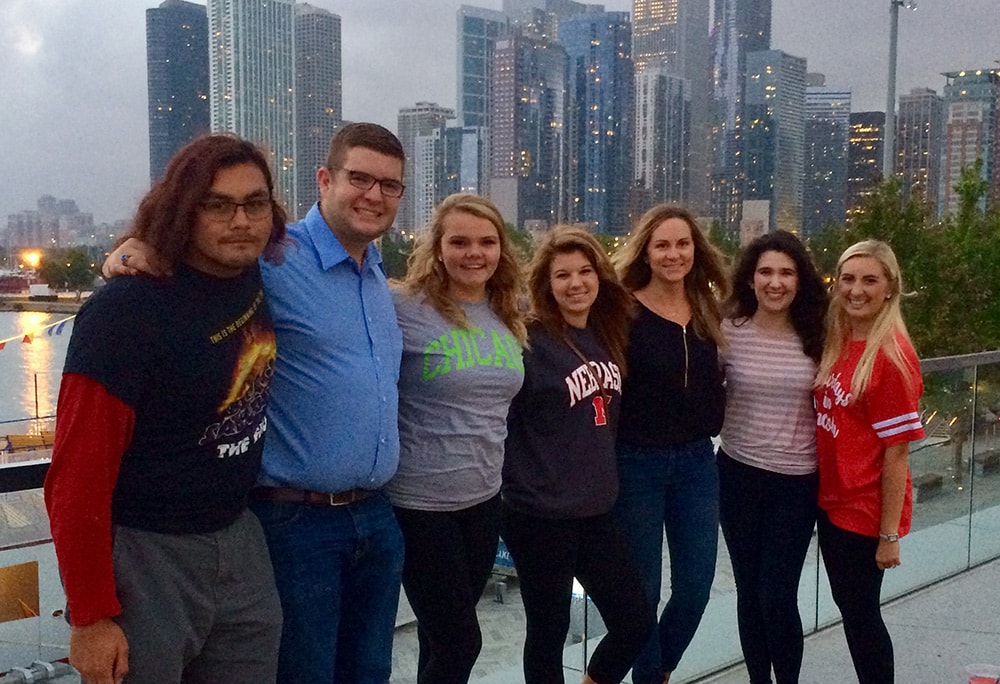 Students lined up for photo with Chicago skyline in background.